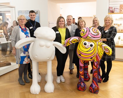 Heart of Kent Hospice staff and local councillors pose with two Shaun the Sheep art sculptures