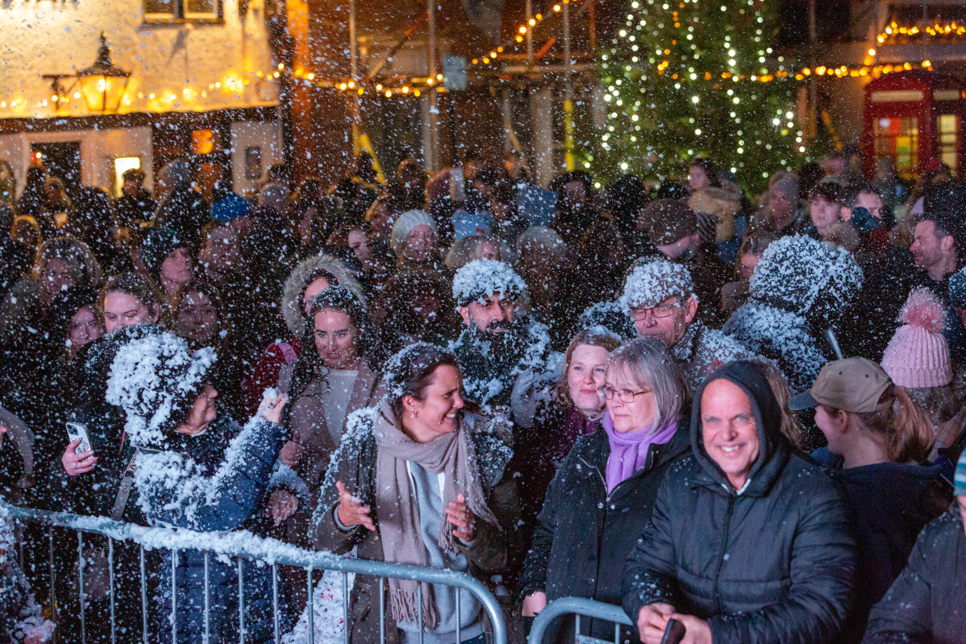 20231203-WMallingXmasFayre-496 A photograph showing the crowd at West Malling Christmas Festival covered in artificial snow