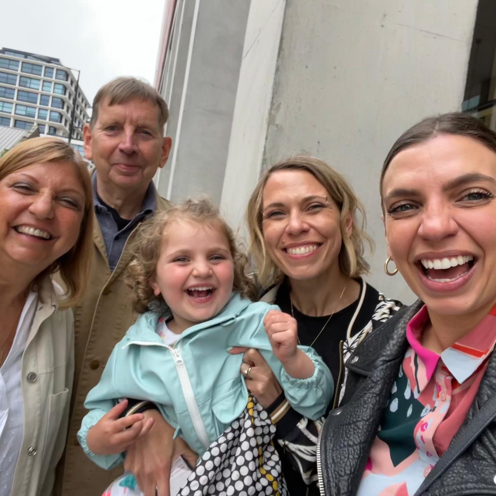 A photograph of a family, 1 man, three women and a girl smiling and laughing