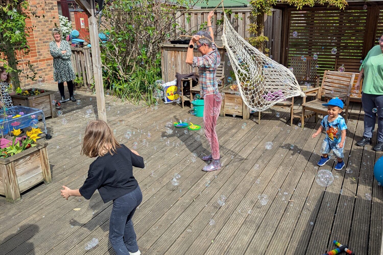Family Support Circus children at the hospice playing with a big bubble net at our Family Support circus workshop